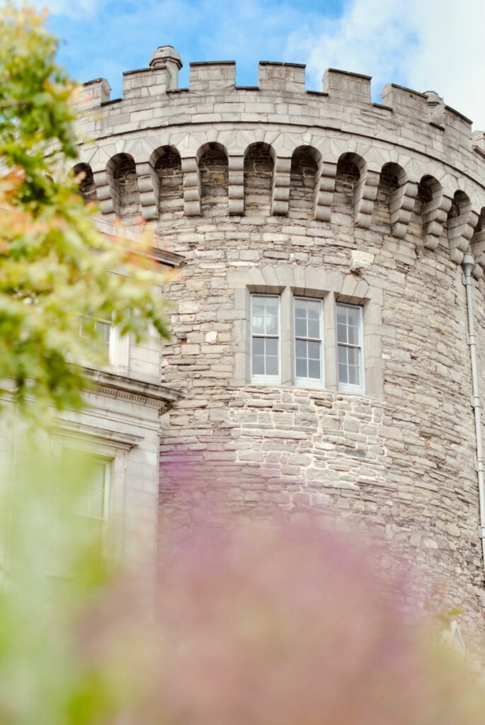 A close-up of a stone tower at Dublin Castle, showcasing the medieval architecture with battlements and stonework details.