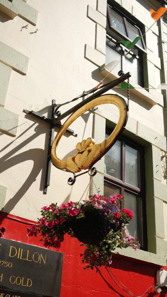 Sign featuring a Claddagh ring outside a traditional Irish jewelry gift shop, a popular symbol and souvenir representing love, loyalty, and friendship in Ireland.