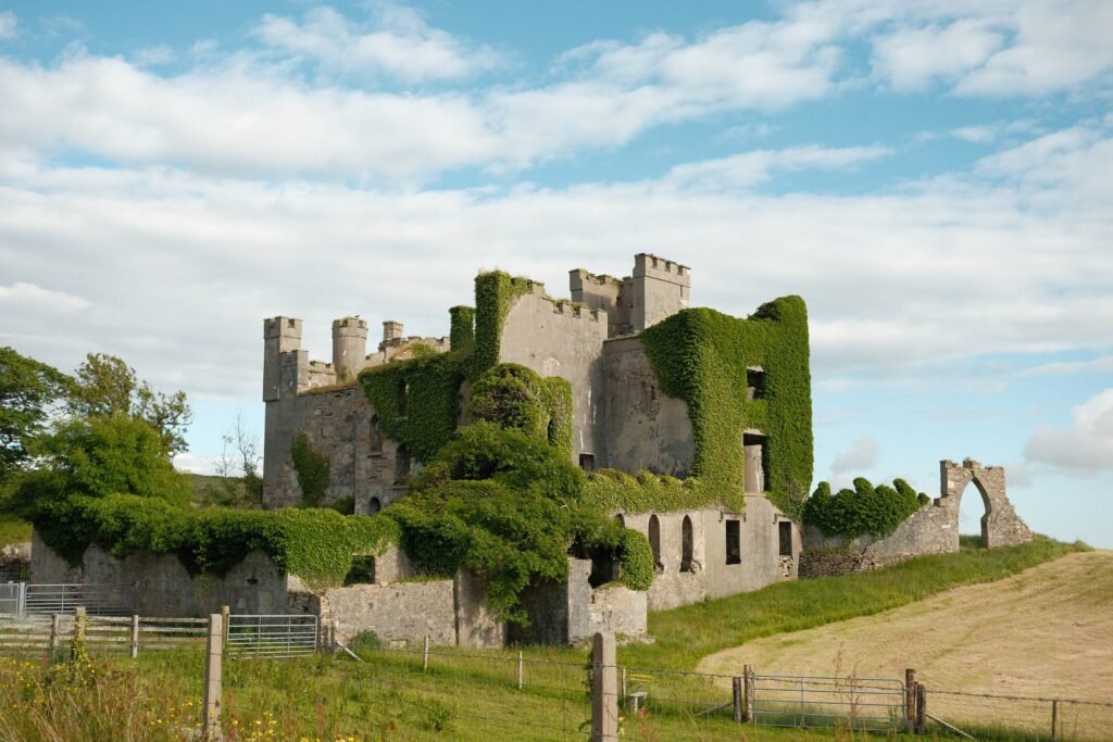 Clifden Castle perched on a hill in the Connemara region of County Galway, Ireland. These castle ruins can be found in Clifden Ireland along the famous Sky Road.