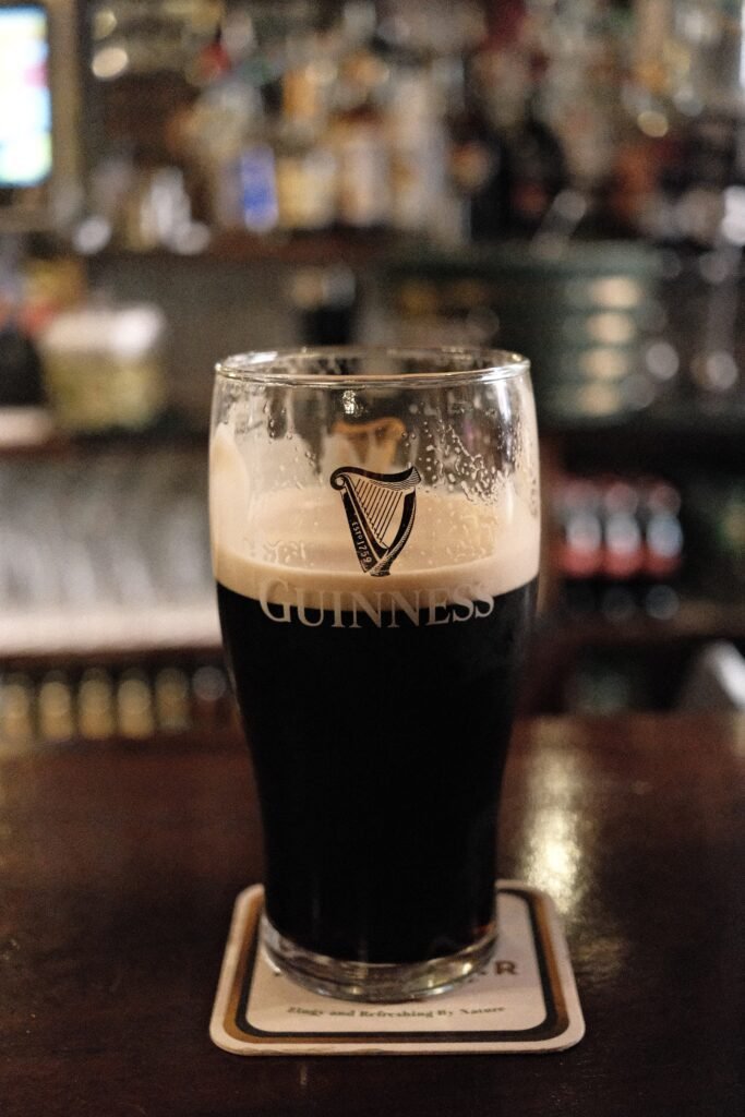 A perfectly poured pint of Guinness sitting on a coaster inside one of the best and most historic Dublin pubs, The Long Hall, capturing the authentic Irish pub experience.