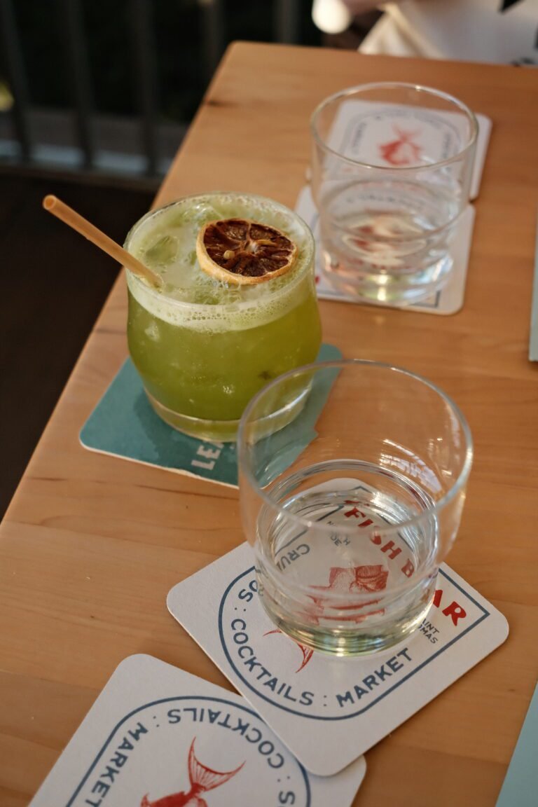 A refreshing green cocktail with a dried lime garnish served at Fish Bar in St. Thomas during a girls' bachelorette dinner and drinks.