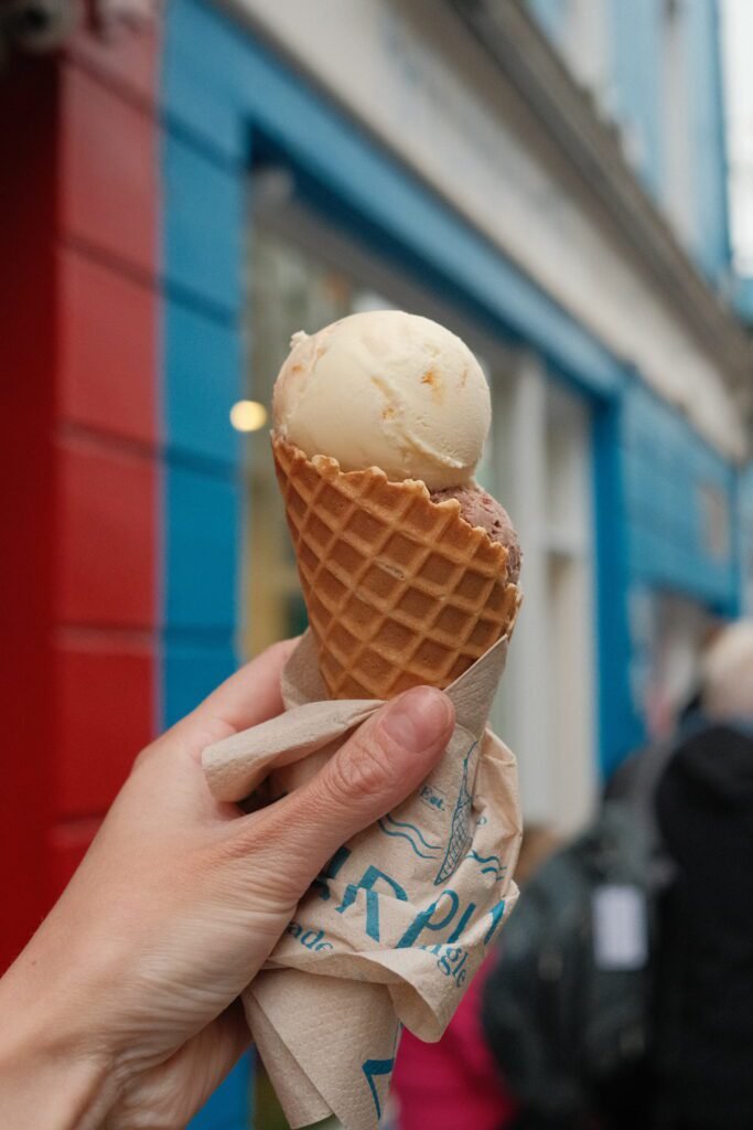 ice cream cone in front of a colorful building in Galway City, showcasing one of the best places to eat dessert. Perfect for those exploring top places to eat and drink in Galway, this local spot is a must-visit for sweet treats.