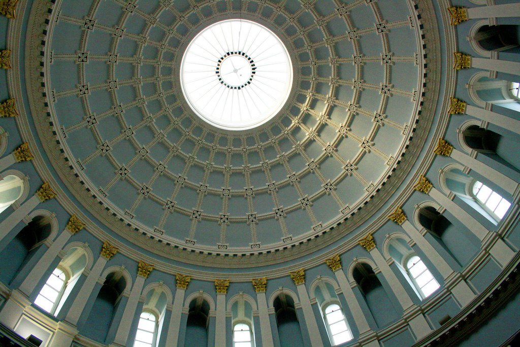 The grand dome ceiling of the National Museum of Archaeology in Dublin, featuring intricate architectural details and a central skylight.