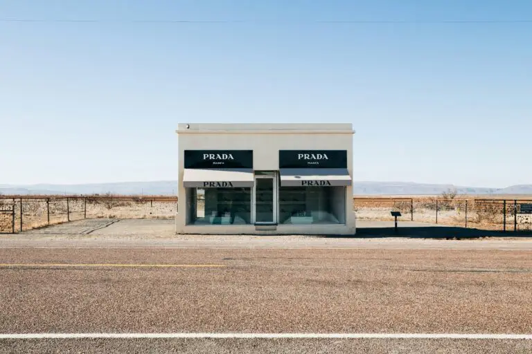 Prada Marfa art installation in the West Texas desert near Marfa, featuring a small building with Prada signage and a backdrop of desert landscape.