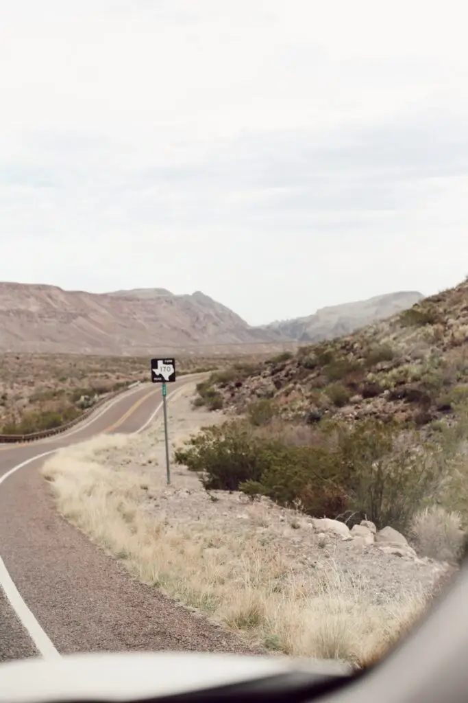 A winding road on Texas Route 170 near Big Bend National Park, surrounded by desert and mountain landscapes.