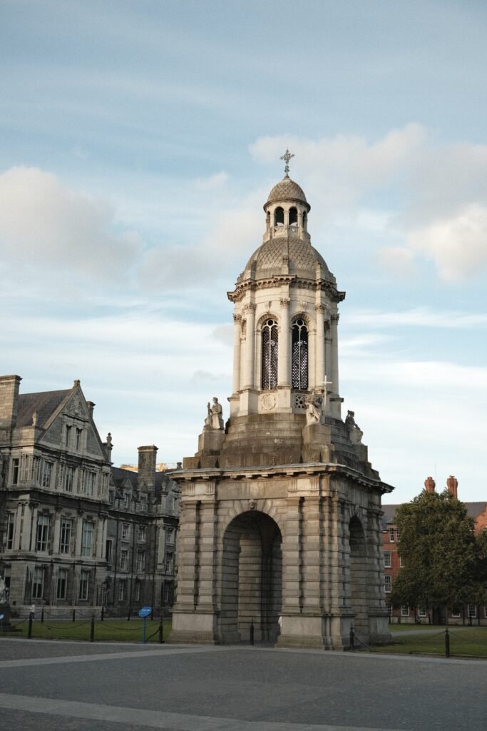 The iconic campanile at Trinity College in Dublin, Ireland, standing tall against the sky. This landmark is not only a symbol of the college's rich history but also a must-visit for book lovers exploring the best bookstores and literary sites in Dublin.