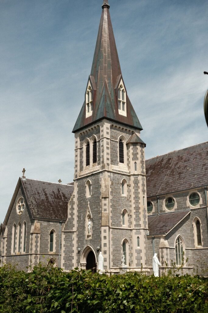 Holy Cross Church, Kenmare, Ireland – A striking Gothic-style church with a towering spire, located in the heart of Kenmare. One of the town's most notable landmarks and a must-see for visitors exploring the rich historical and architectural sites of County Kerry.