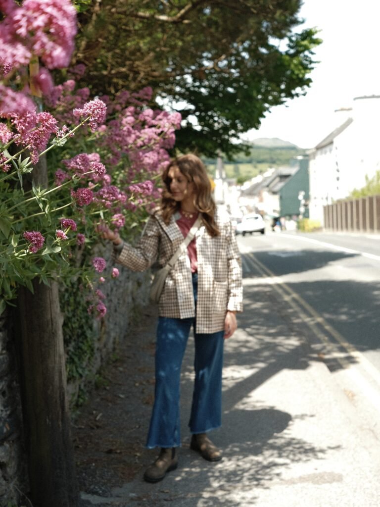 Traveler strolling through the streets of Kenmare, Ireland – Admiring vibrant flowers along the charming streets of Kenmare, a picturesque town in County Kerry. Perfect for visitors exploring the local culture and scenic beauty of the village.